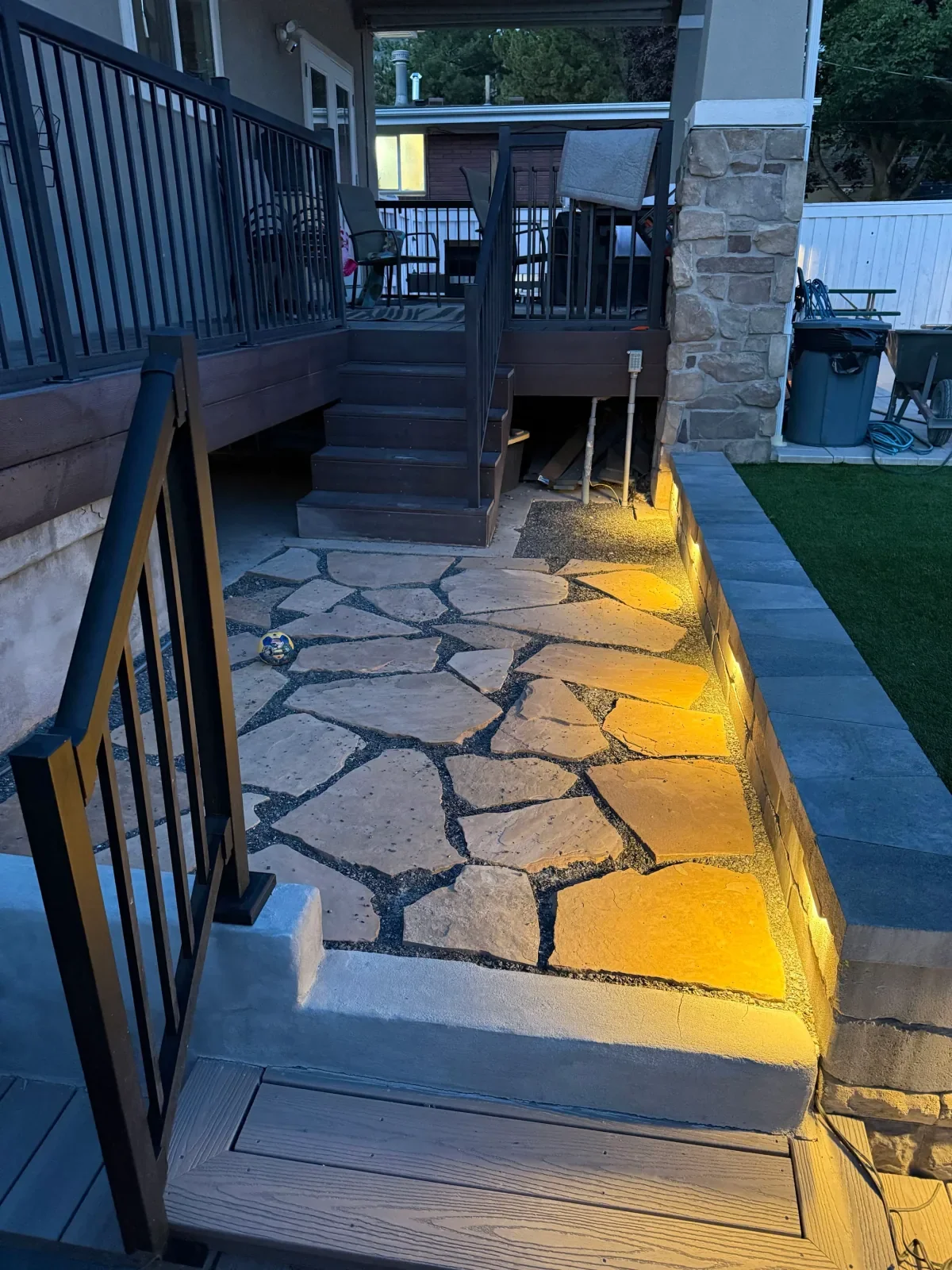 Client hardscape patio illuminated by warm retaining-wall lights