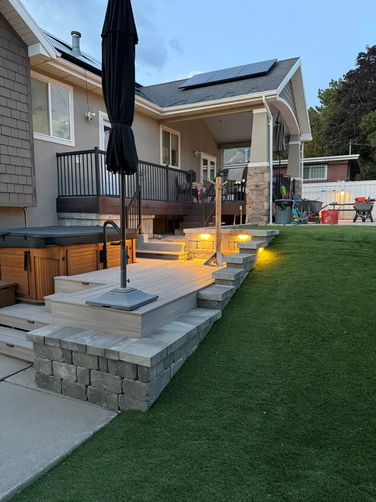 Client deck, retaining walls, and outdoor lighting at dusk