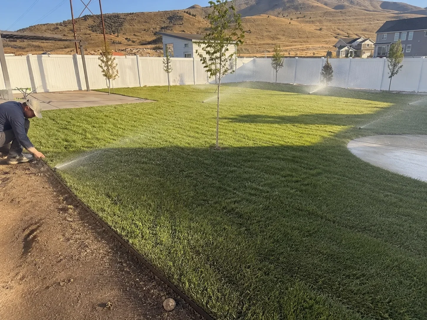 Monarch team member testing sprinklers across a newly established Utah lawn